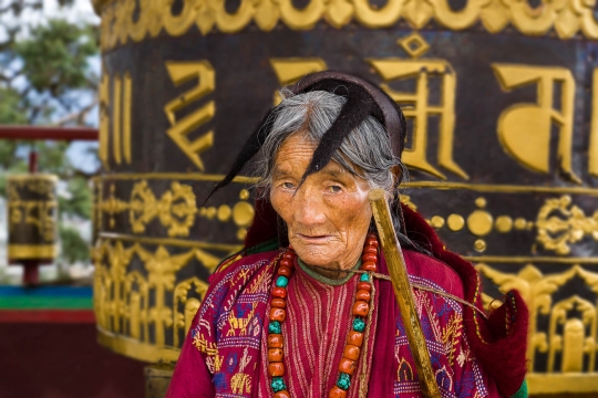 Traditional Monpa woman turning prayer wheels
