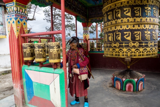 Traditional Monpa woman turning prayer wheels