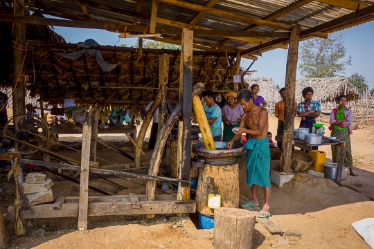 Family making paste from peanuts