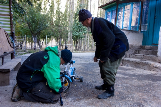 Bertrand trying to fix the tire of a small bike